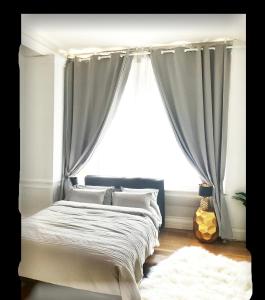 a bed in a bedroom with a window with curtains at PICCADILLY Private room and bathroom in Manchester