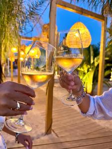two people holding up glasses of white wine at Villa Denise in Pulsano