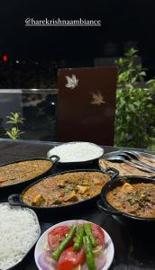 a table topped with trays of food and rice at NIKUNJ VAN By Hare Krishna Ambiance in Vrindāvan