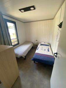 a small room with a bed and a window at chalet de l'Edune 6 pers beau standing piscine couverte à 150m de la mer wifi inclus in Jullouville-les-Pins +9 photos