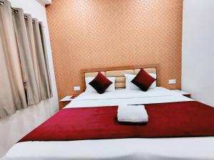 a bedroom with a large white bed with red pillows at NIKUNJ VAN By Hare Krishna Ambiance in Vrindāvan
