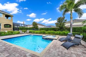 キシミーにあるSpacious Home Near Disney With Game And Themed Rooms With Waterpark & Resort Access At Encore Resorts Reunion - 581Laの椅子2脚とヤシの木が置かれたプール