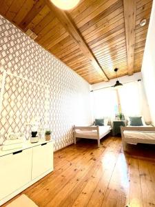ヴロツワフにあるAViendo Lodgeの木製の床のリビングルームとベッドが2つある部屋