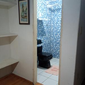 a bathroom with a black toilet and a shower at Casinhas de Pipa in Pipa