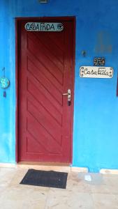 a red door on the side of a blue wall at Casinhas de Pipa in Pipa