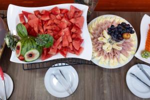 a table with a plate of watermelon and fruit at Hotel Apartamentos Regency La Feria in Bogotá