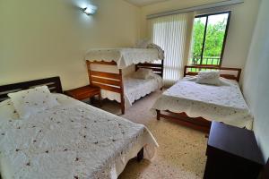 a bedroom with two beds and a window at Villa Hortencia in Fusagasuga +49 photos