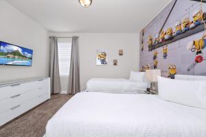 ein weißes Schlafzimmer mit 2 Betten und einem TV in der Unterkunft Regal Home With Private Pool Near Disney With Waterpark & Resort Access At Encore Resort - 7727Ff in Kissimmee