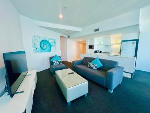ゴールドコーストにあるLuxe Skyline 2B Apt at SkyPointのソファとテレビのあるリビングルーム