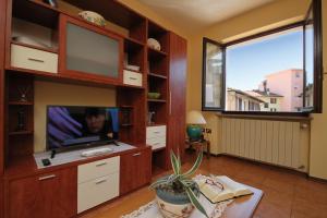 Una sala de estar con televisión y una gran ventana. en Sunset in Baveno - Happy Rentals, en Baveno