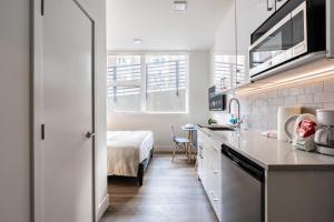a kitchen with a sink and a bed in a room at Cityscape Condotel on First Hill-Capitol Hill in Seattle