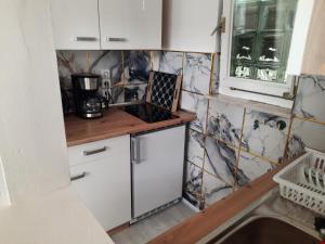 a kitchen with white cabinets and a stove top oven at Bungalow Mika und Lizzy in Koserow +18 photos