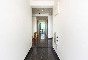 a hallway with white walls and black flooring at Hotel O Qualia Inn Kondapur Near Botanical Garden in Hyderabad