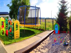 a playground with a trampoline in the sand at Comfortable holiday homes with terraces in Przewłoka