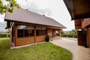 a wooden building with a porch and grass at Agroturystyka Pawlikówka in Lipniki