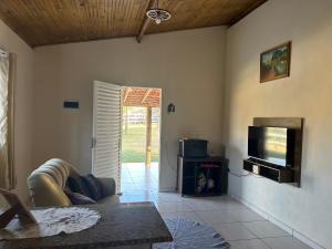 a living room with a flat screen tv and a couch at Casa de Campo Sitio com tranquilidade in Cunha