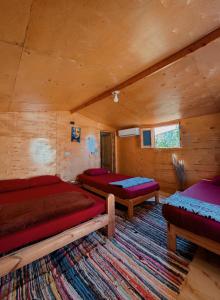 a room with three beds in a log cabin at Seavia Camp in Nuweiba
