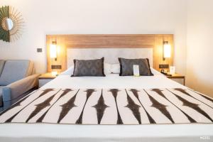 Un dormitorio con una cama grande y un sofá. en Riu Jalisco - All Inclusive, en Nuevo Vallarta 