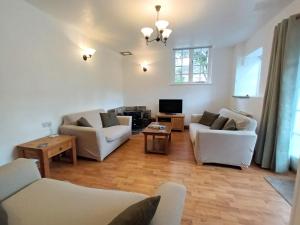 a living room with two white couches and a tv at Farm Stay with animal experiences, 30 minutes to Exmoor & Beaches, Pet friendly, Outdoor heated pool, Games barn, fast WiFi and parking in Barnstaple