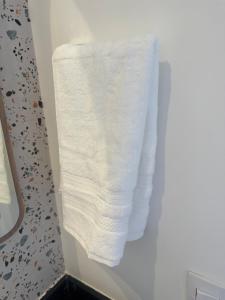 a stack of white towels hanging on a wall in a bathroom at Uma delícia de Ap para SP! in Sao Paulo