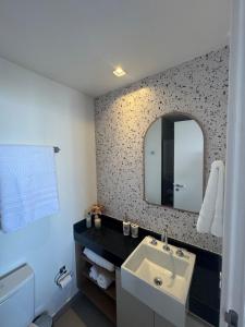 a bathroom with a sink and a mirror at Uma delícia de Ap para SP! in Sao Paulo +32 photos