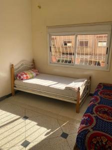 a bed sitting in a room with a window at Azrou in Azrou