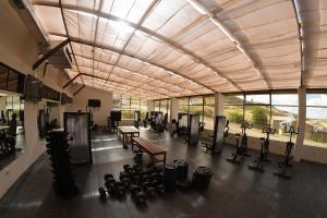 a gym with rows of exercise equipment in a building at CAR Sport Hotel Titikaka in Huarina