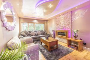a living room with a couch and a fireplace at Hot Tub and Garden Spacious Unique 3 Bed House in Allesley