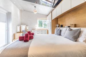 a bedroom with a large white bed with red pillows at Hot Tub and Garden Spacious Unique 3 Bed House in Allesley