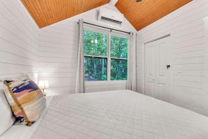 a white bedroom with a bed and a window at Dogwood Cottage with Private Fire Pit & Sleeps 6 in Menlo