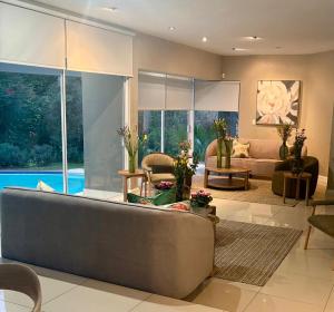 a living room with a large couch and a large window at Wellness Guesthouse in Krugersdorp