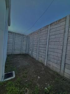 un patio trasero vacío con una pared de ladrillos en Tu lugar tranquilo cerca de todo, en San Miguel