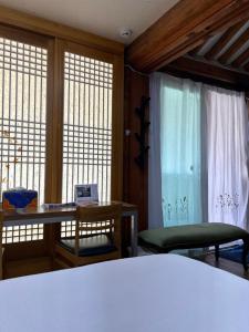 ソウルにあるEugene Hanok Stayのベッドと机と窓のある寝室