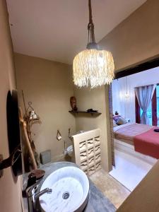 Un baño con lavabo y un dormitorio con cama. en Pondok Dembe, en Uluwatu 4 fotos más