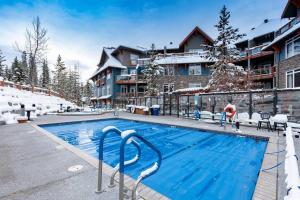 a swimming pool in a resort in the snow at Sun Drenched Escape in Canmore