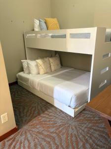 a bedroom with a bunk bed with white sheets and pillows at Sun Drenched Escape in Canmore +27 photos