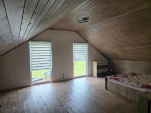 an attic room with a bed and two windows at Friend's homestead 