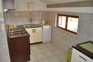 a small kitchen with a sink and a stove at Apartments Pavić in Betina