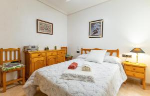 a bedroom with a bed and two tables and a chair at 2 Bedroom Amazing Apartment In Torrevieja in Torrevieja +9 photos