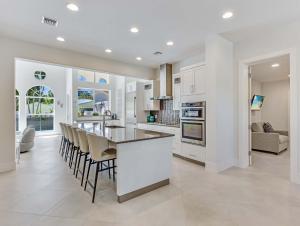 a kitchen and living room with white cabinets and a counter at Casa Captiva - Deluxe 5 Bedroom Villa Steps to Beach in Captiva