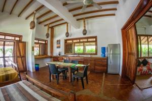 a kitchen with a table and chairs and a refrigerator at Canoa Suites in Canoa