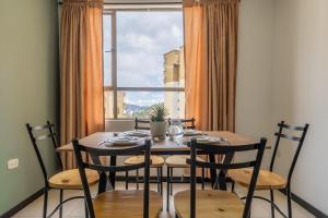 パストにあるMA2-1108 Comodo Apartamento Vista-Volcán En Aquineのダイニングテーブルと椅子、そして大きな窓