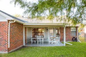 a brick house with a patio with tables and chairs at The Cooper Nest in Garland