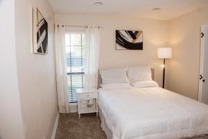 a white bedroom with a bed and a window at The Cooper Nest in Garland
