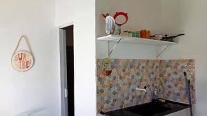 baño con lavabo y estante en la pared en Studio Marola, Aconchego na Rua Mais Charmosa, en Itacaré 5 fotos más