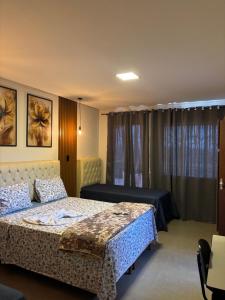 una camera con due letti e una finestra con tende di Dinho's Hotel e Restaurante a Nazareno