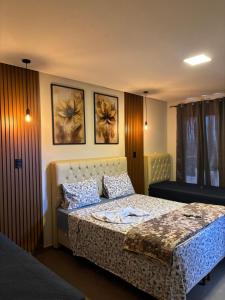 una camera da letto con un letto e due quadri sul muro di Dinho's Hotel e Restaurante a Nazareno