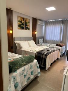 una camera d'albergo con tre posti letto di Dinho's Hotel e Restaurante a Nazareno