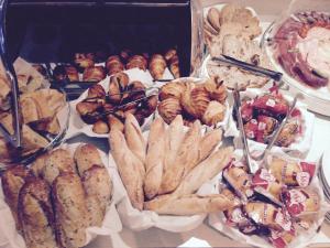 a table filled with different types of pastries and bread at Hotel Suisse in Nice