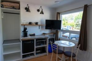 a small kitchen with a table and a tv at Motel Glenn in Perce